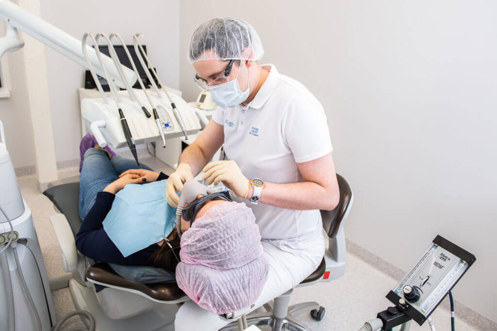 Врач лечит зубы пациенту под седацией